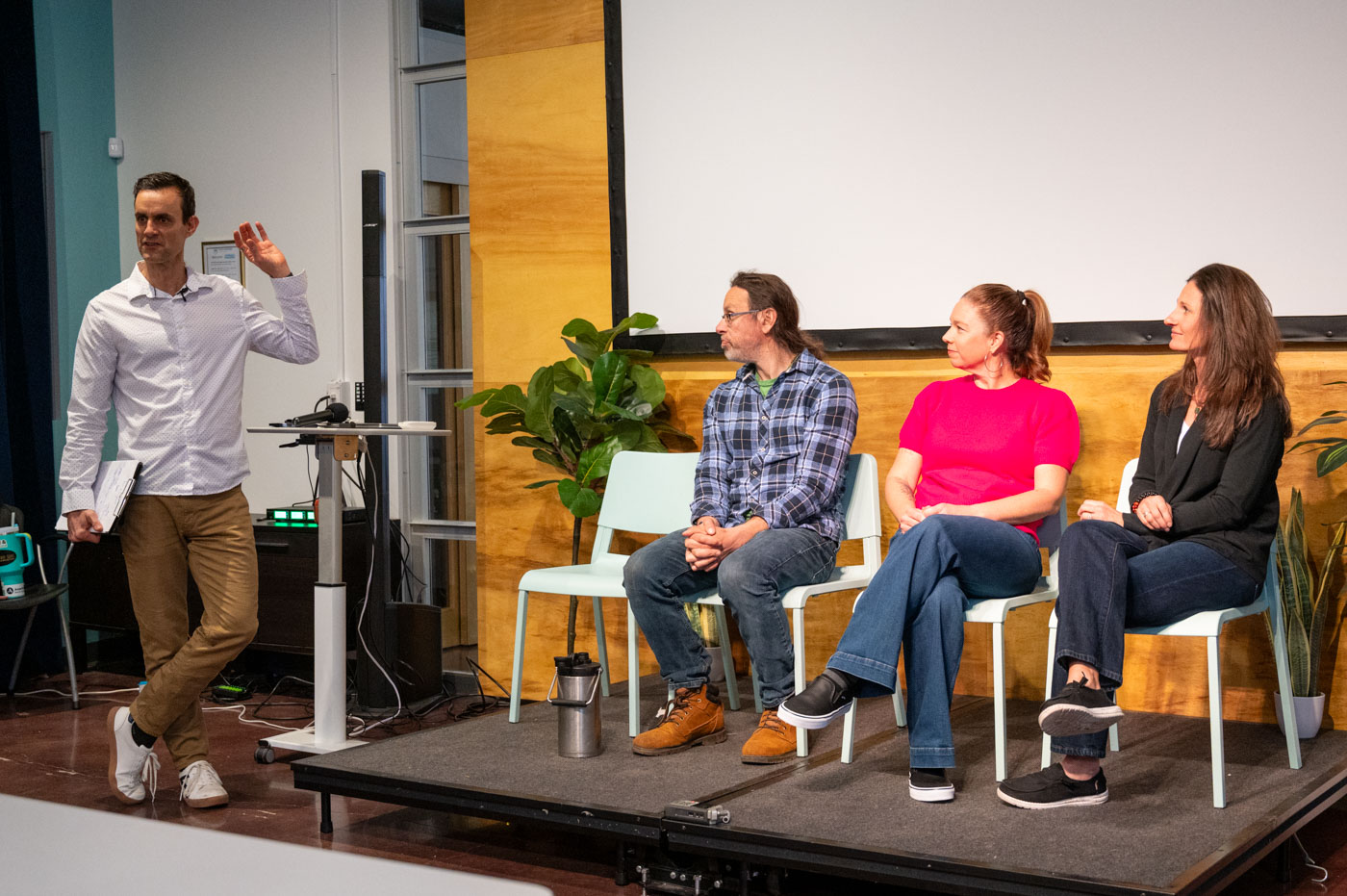 Travis Richardson speaking on stage to an engaged audience